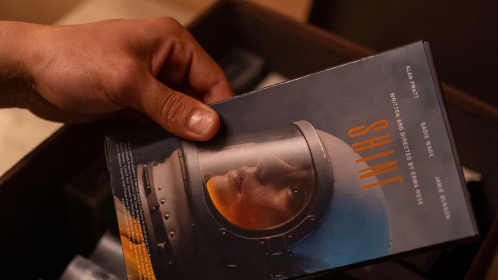 A hand lifting a book from a boxed set of matching editions