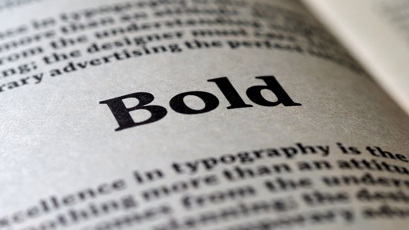 Printed book pages showing body text typography, representing choosing a book interior font