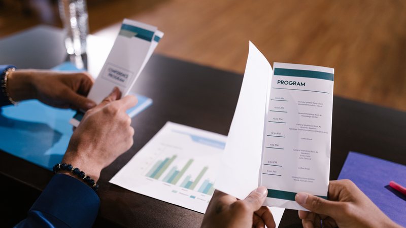 A team collaborating over documents at a desk, representing company profile and brochure design