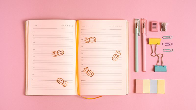 An open planner with a weekly layout on a desk, representing planner and dated journal formatting