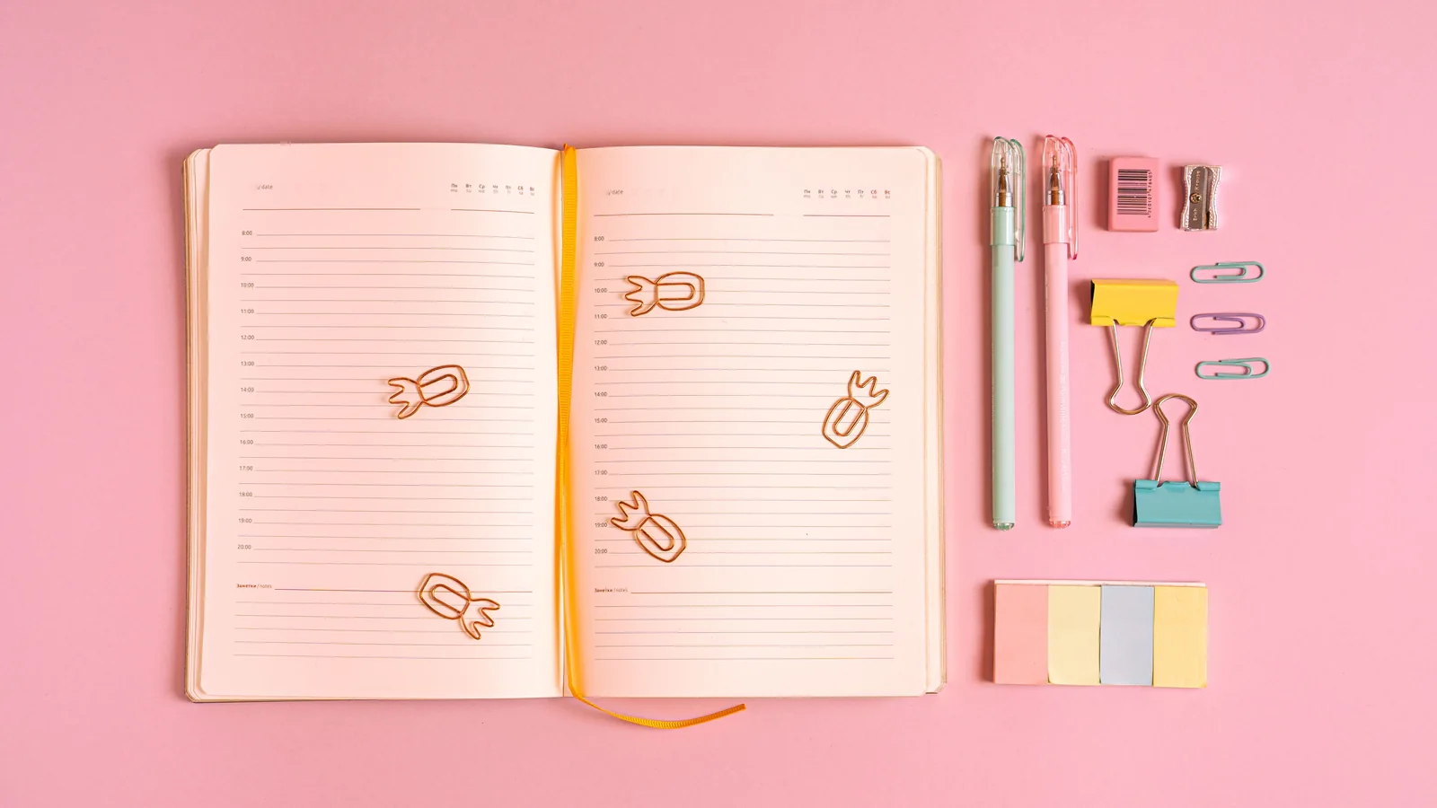An open planner with a weekly layout on a desk, representing planner and dated journal formatting