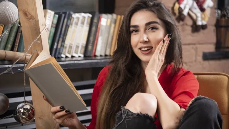 Young woman sitting and holding a book