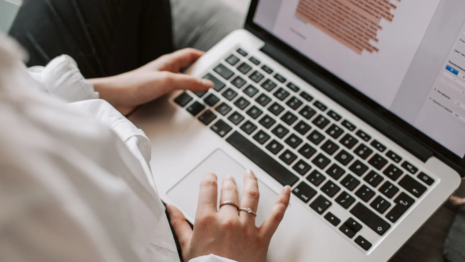 A person typing on a laptop with a document open, representing writing a book description